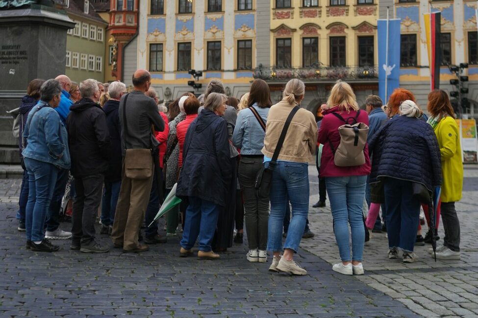 Eine Gruppe während des Abendspazirgangs vor dem Rathaus