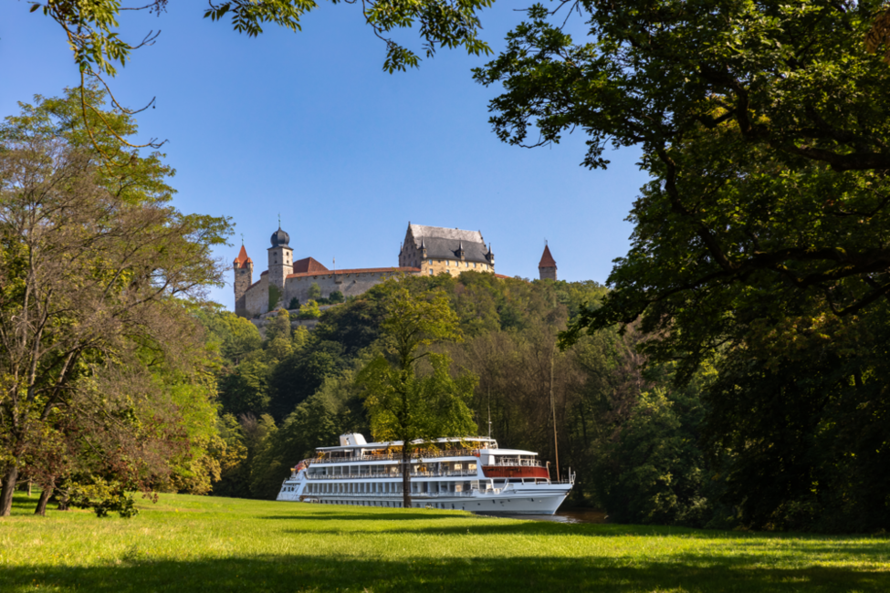 KI generiertes Bild, das ein Flusskreuzfahrtschiff vor der Veste Coburg zeigt