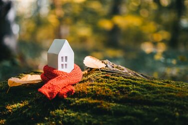 Miniature,House,In,A,Red,Scarf,On,An,Autumn,Background