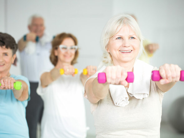 Elderly,Women,Holding,Dumbbells,During,Group,Exercise,Class,For,Senior