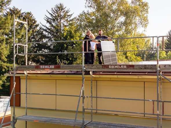 Arbeiter montieren die neue PV-Anlage auf dem Dach der Rolf-Forkel-Halle in Lützelbuch.