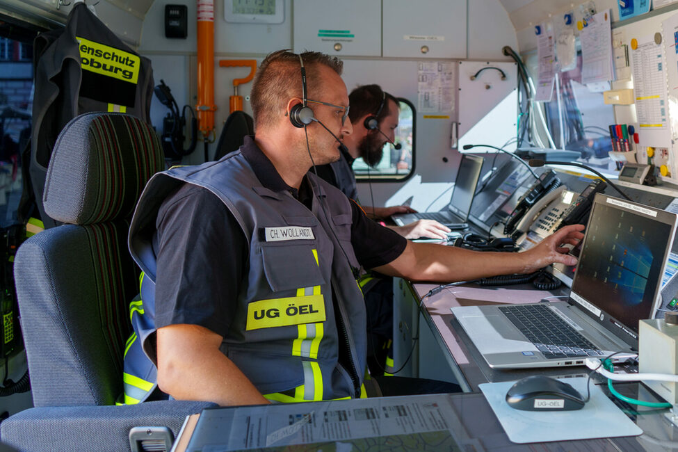 Zwei Mitglieder der UG ÖEL arbeiten im Einsatzfahrzeug.
