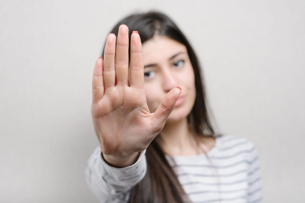 A,Woman,Shows,A,Stop,On,A,Grey,Background