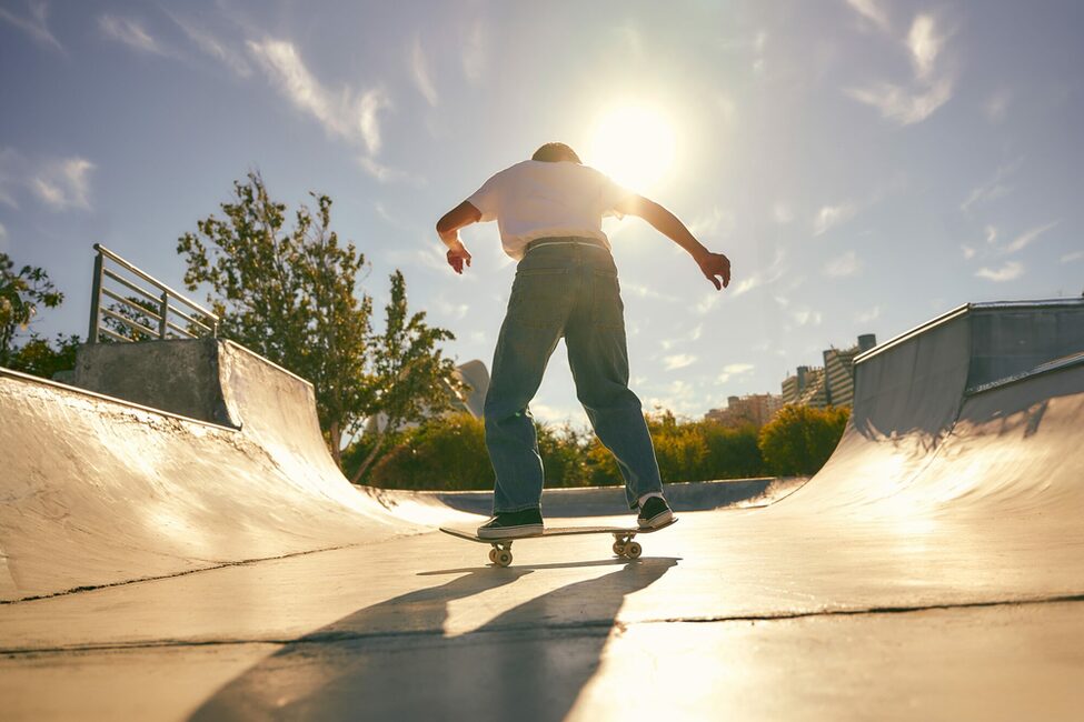 Back,View,Of,Young,Skateboarder,Flies,With,His,Board,On