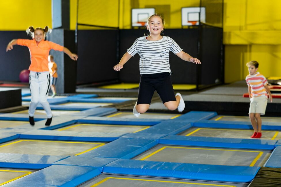 Joyful,School-age,Girl,In,Casual,Clothes,Bouncing,On,Trampolines,Indoors