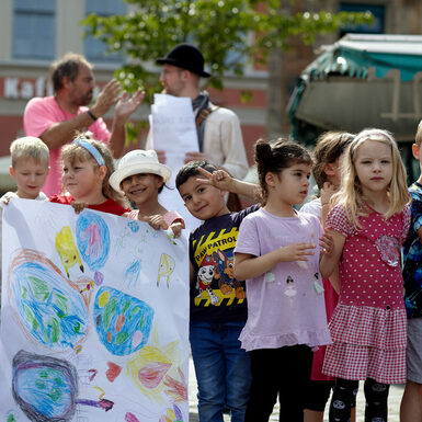 Kinder halten selbstgemalte Plakate zum Thema Toleranz