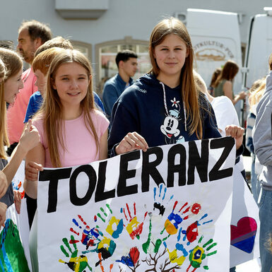Verschiedene Kinder halten selbst gemalte Plakate in der Hand auf denen das Wort "Toleranz" abgebildet ist