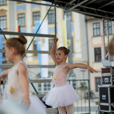 Eine Gruppe von Kindern in Ballettkleidung steht auf der Bühne und tanzen.